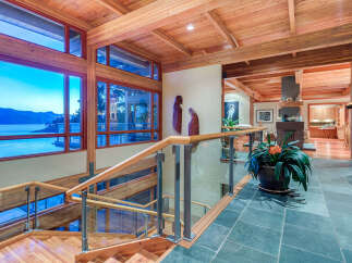 This stunning home boasts a spacious open floor plan with walls of windows offering breathtaking water views.