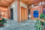 This stunning foyer boasts a spacious and bright design, featuring a beautiful slate tile floor and wood-beamed ceiling.