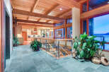 This stunning home boasts a spacious open floor plan with high ceilings, exposed wooden beams, and large windows offering breathtaking water views.