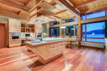 This stunning kitchen boasts a unique wooden ceiling and large windows offering breathtaking water views.