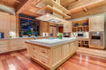 This stunning kitchen boasts a large island with ample storage, a high-end range, and a built-in desk area.