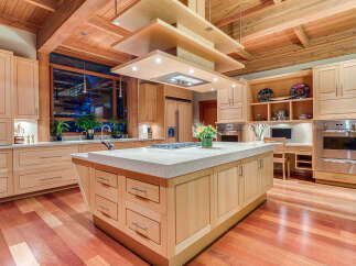 This stunning kitchen boasts a large island with ample storage, a high-end range, and a built-in desk area.