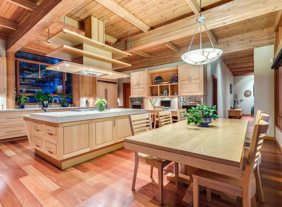 This stunning kitchen boasts a large island with ample counter space, custom wooden cabinetry, and high-end appliances.