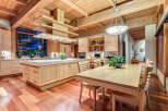This stunning kitchen boasts a large island with ample counter space, custom wooden cabinetry, and high-end appliances.