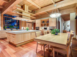 This stunning kitchen boasts a large island with ample counter space, custom wooden cabinetry, and high-end appliances.