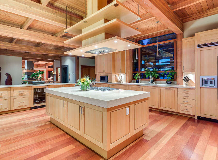 This stunning kitchen boasts a large island with a granite countertop, custom wooden cabinetry, and high-end appliances.