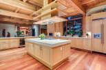 This stunning kitchen boasts a large island with a granite countertop, custom wooden cabinetry, and high-end appliances.