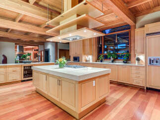 This stunning kitchen boasts a large island with a granite countertop, custom wooden cabinetry, and high-end appliances.