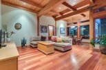 This stunning home boasts a spacious living area with hardwood floors, a cozy sectional sofa, and a wood-paneled ceiling.