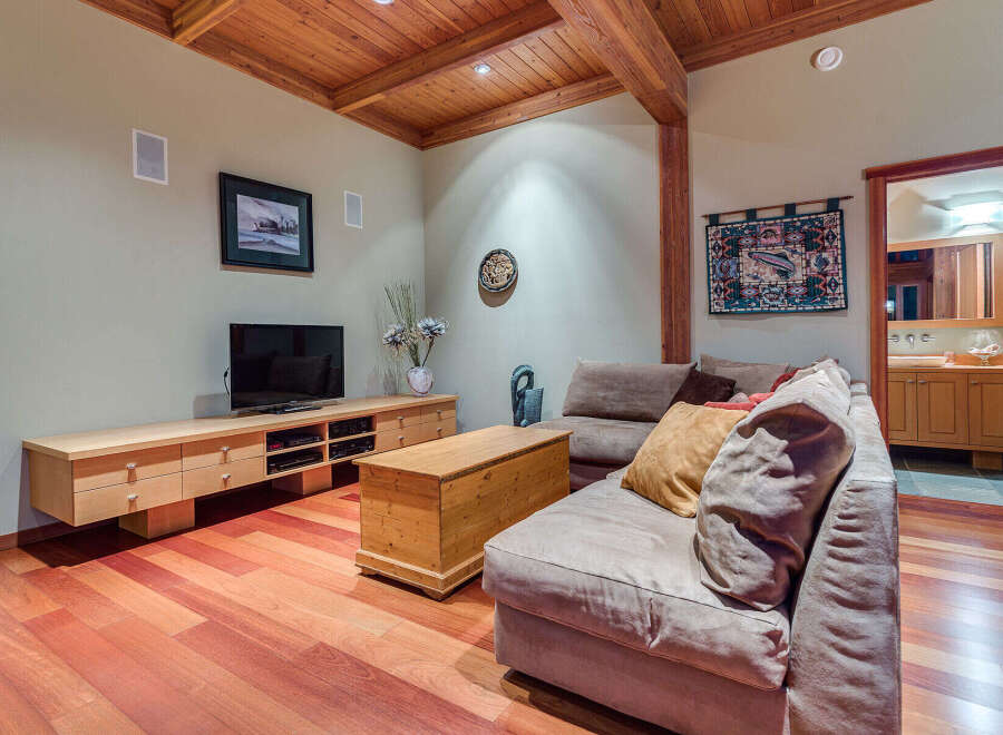 This cozy family room boasts a built-in entertainment center, hardwood floors, and a comfortable sectional sofa perfect for movie nights.