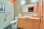 This stunning bathroom boasts a light and airy feel, with soft green walls and light wood cabinetry.