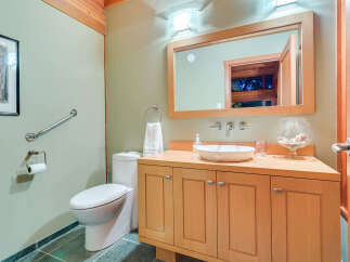 This stunning bathroom boasts a light and airy feel, with soft green walls and light wood cabinetry.