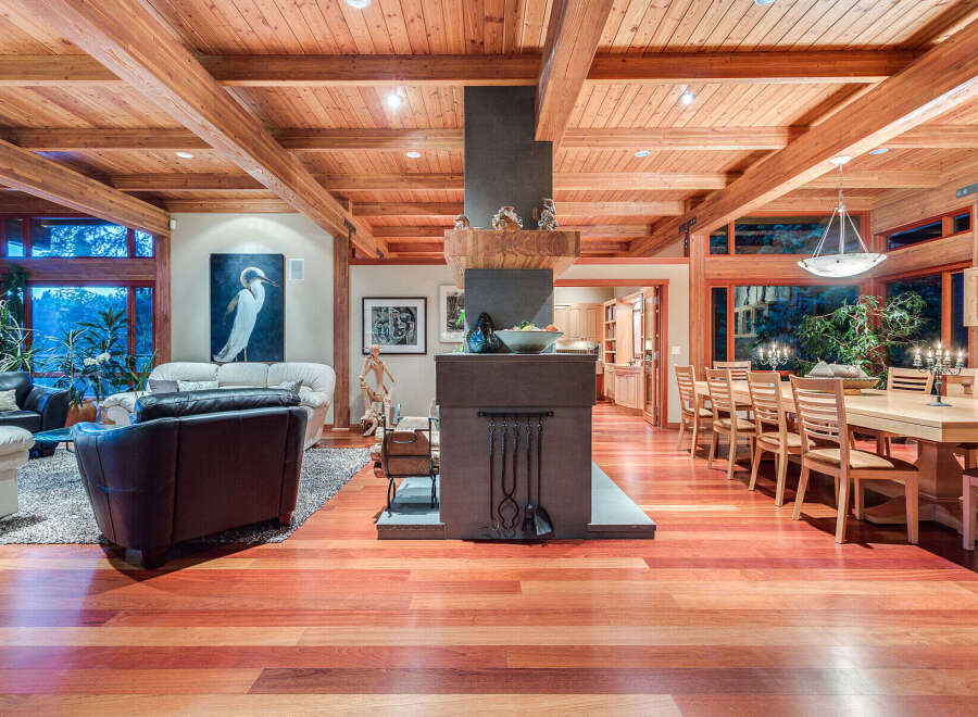 This stunning home boasts a spacious open floor plan with hardwood floors, high ceilings with exposed beams, and large windows offering abundant natural light.
