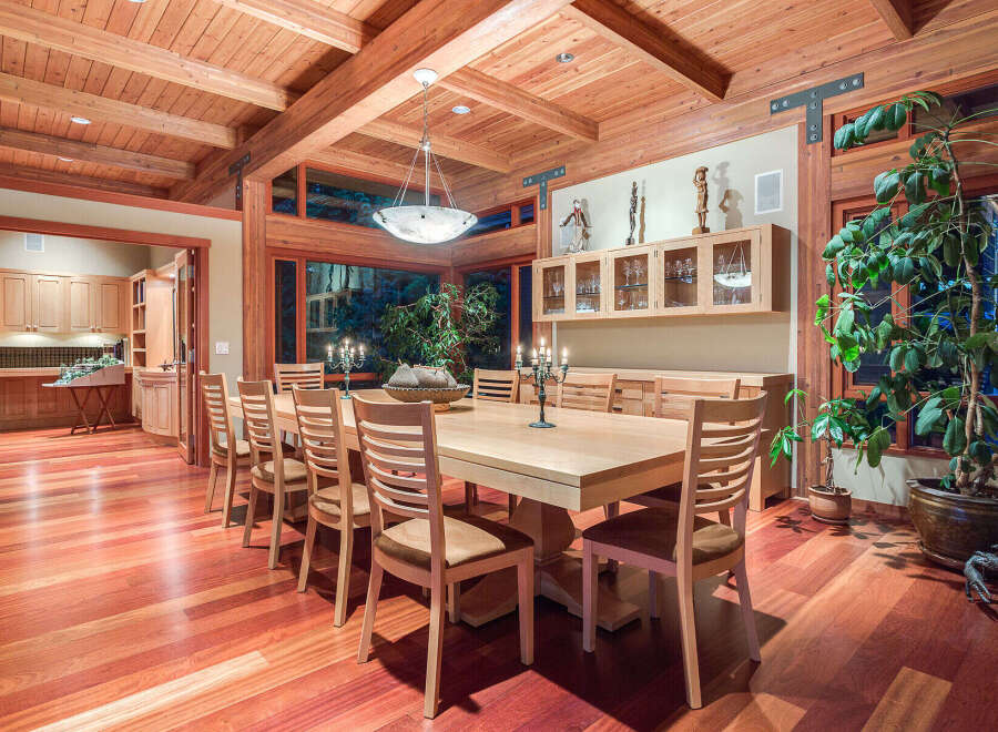 This stunning dining room boasts a large, light-wood table surrounded by comfortable chairs, perfect for family gatherings.