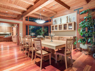 This stunning dining room boasts a large, light-wood table surrounded by comfortable chairs, perfect for family gatherings.