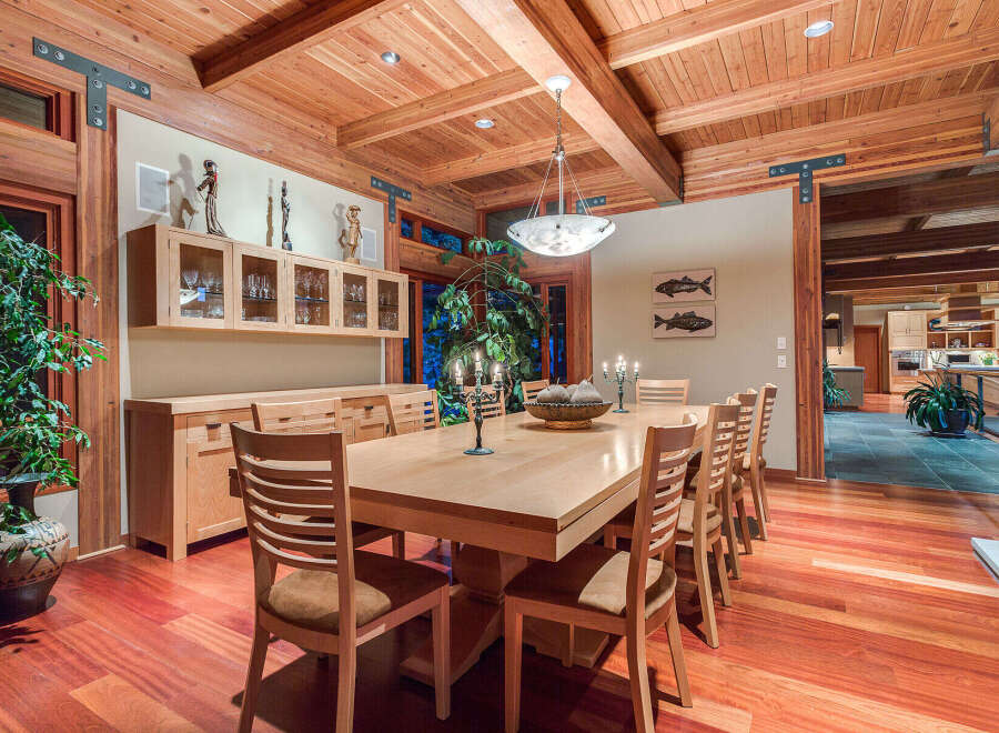This stunning dining room boasts a large, light-wood table surrounded by comfortable chairs, perfect for family gatherings.