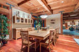 This stunning dining room boasts a large, light-wood table surrounded by comfortable chairs, perfect for family gatherings.