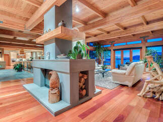 This stunning home boasts a spacious open floor plan with hardwood floors, high ceilings, and large windows offering breathtaking views.