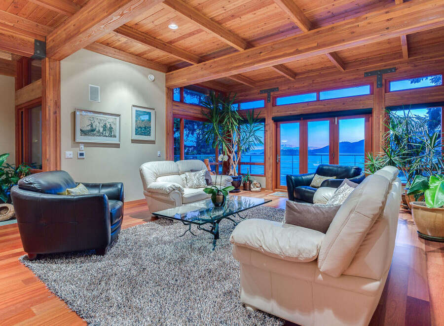 This stunning waterfront property boasts a spacious living area with floor-to-ceiling windows offering breathtaking views.