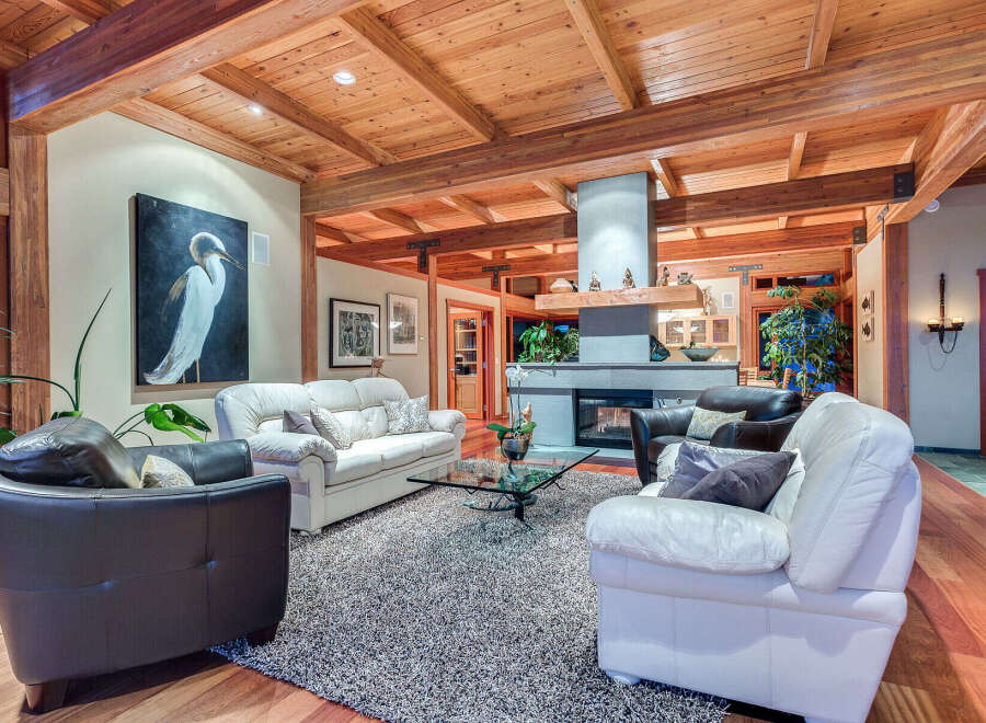 This stunning living room boasts a high, wood-beamed ceiling, creating a warm and inviting atmosphere.