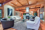 This stunning living room boasts a high, wood-beamed ceiling, creating a warm and inviting atmosphere.