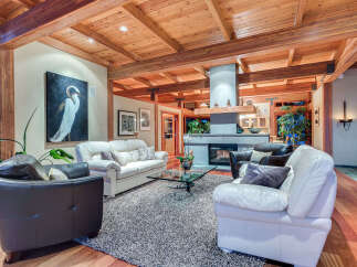 This stunning living room boasts a high, wood-beamed ceiling, creating a warm and inviting atmosphere.