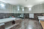 This luxurious bathroom boasts a spacious design with a large soaking tub, a walk-in shower with glass enclosure, and double sinks.