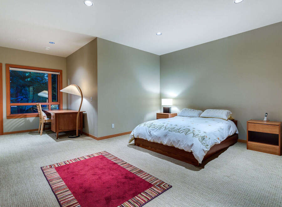 This bedroom boasts a tranquil ambiance with its neutral walls and plush carpeting.