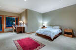This bedroom boasts a tranquil ambiance with its neutral walls and plush carpeting.
