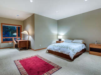 This bedroom boasts a tranquil ambiance with its neutral walls and plush carpeting.