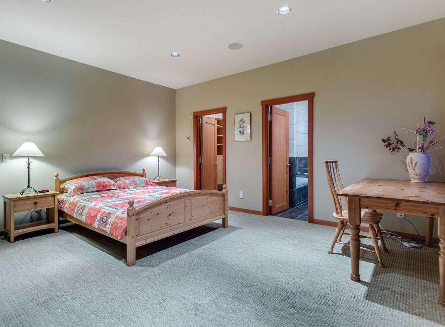 This charming bedroom boasts a cozy atmosphere with its light-colored walls and carpeted floors.