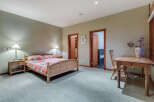 This charming bedroom boasts a cozy atmosphere with its light-colored walls and carpeted floors.