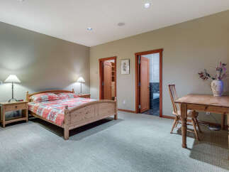 This charming bedroom boasts a cozy atmosphere with its light-colored walls and carpeted floors.