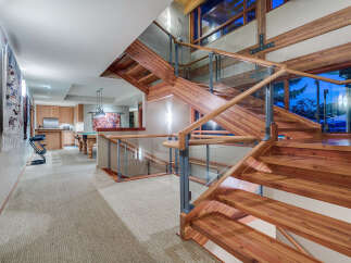 This stunning home boasts a grand, double staircase crafted from rich wood, creating a striking focal point in the open-plan layout.
