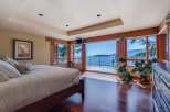 This luxurious bedroom boasts breathtaking ocean views from its expansive windows and private balcony.
