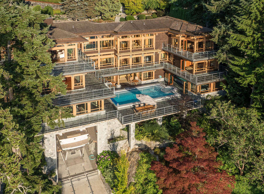 This stunning waterfront property boasts a multi-level home with expansive windows offering breathtaking views, a private infinity pool and hot tub, and a boat lift for convenient water access.