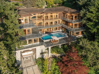 This stunning waterfront property boasts a multi-level home with expansive windows offering breathtaking views, a private infinity pool and hot tub, and a boat lift for convenient water access.