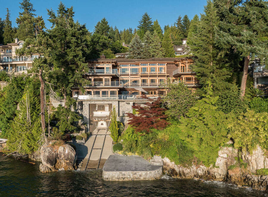 This stunning waterfront property boasts a multi-level home with expansive windows offering breathtaking views, a private boat lift for convenient water access, and lush landscaping creating a secluded oasis.