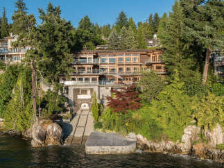 This stunning waterfront property boasts a multi-level home with expansive windows offering breathtaking views, a private boat lift for convenient water access, and lush landscaping creating a secluded oasis.