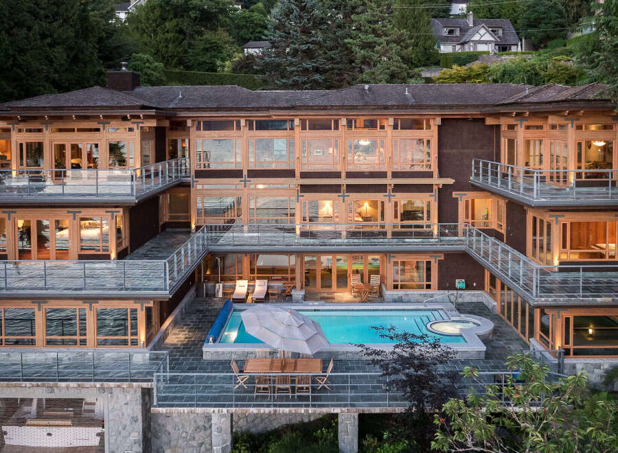 This stunning multi-level home boasts breathtaking waterfront views, expansive decks with glass railings, and a luxurious outdoor oasis complete with a swimming pool and hot tub.