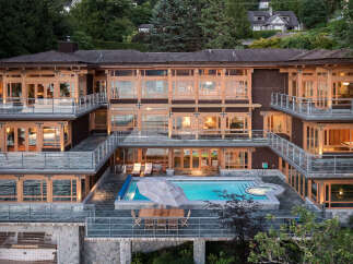 This stunning multi-level home boasts breathtaking waterfront views, expansive decks with glass railings, and a luxurious outdoor oasis complete with a swimming pool and hot tub.