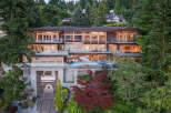 This stunning waterfront mansion boasts a multi-level design with expansive windows offering breathtaking views, a private infinity pool, and a built-in boat lift for convenient water access.