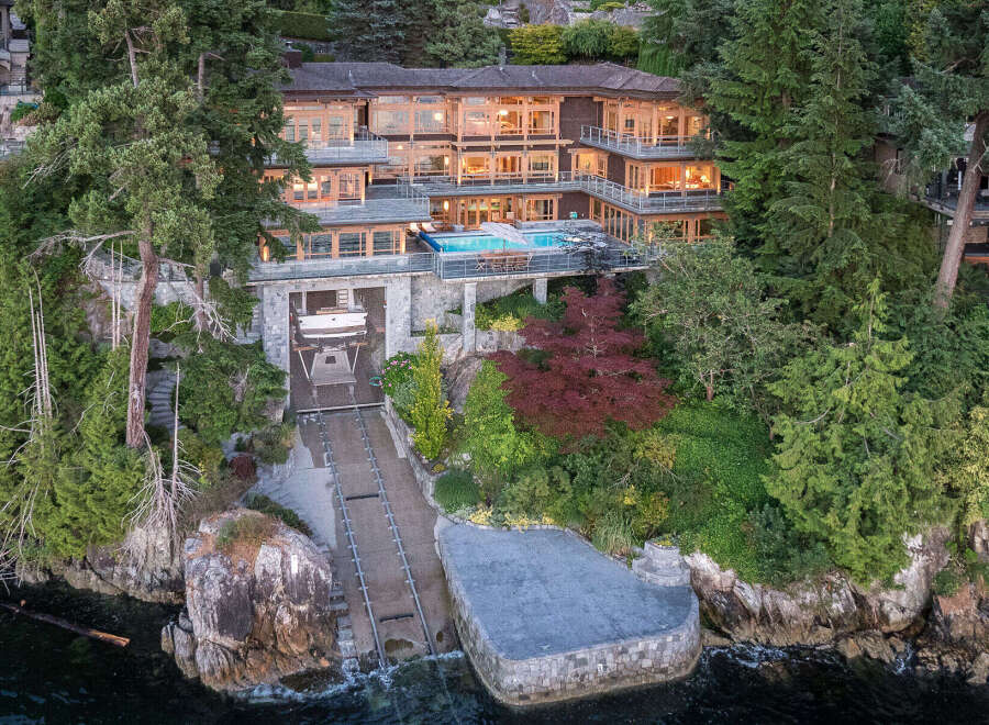 This stunning waterfront property boasts a multi-level home with expansive windows offering breathtaking views, a private infinity pool, and a convenient boat lift for effortless water access.