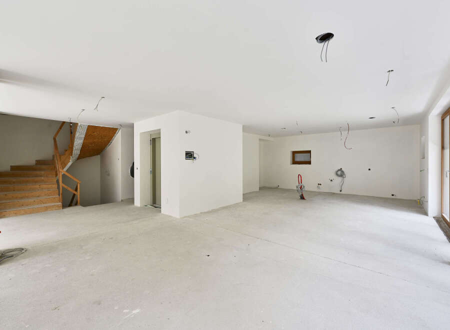 This stunning property boasts a spacious open-plan living area with high ceilings and large windows, creating a bright and airy atmosphere.