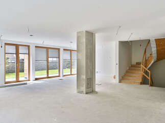 This stunning property boasts a spacious open-plan living area with large windows offering ample natural light and views of the lush green surroundings.