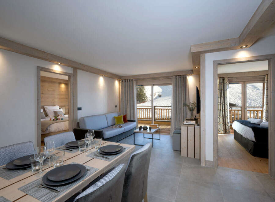 This stunning apartment boasts an open-plan living area with a comfortable sofa, a dining table for four, and breathtaking views from its balcony.