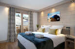 This stunning bedroom boasts a cozy and luxurious atmosphere, complete with a plush bed, soft furs, and elegant curtains.