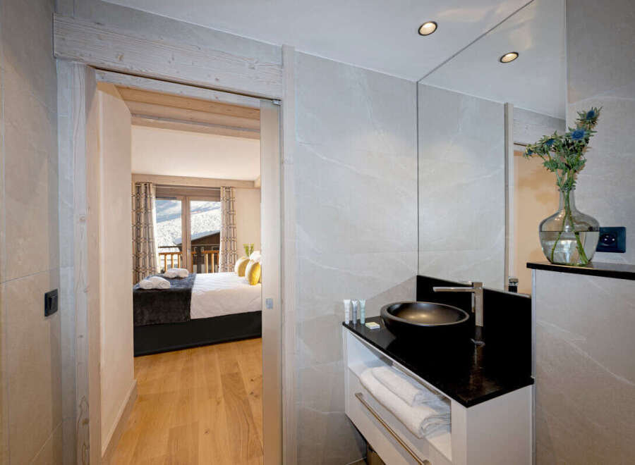 This luxurious bathroom boasts a modern design with sleek black fixtures and a spacious vanity, offering ample storage.