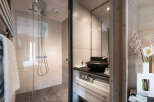 This modern bathroom boasts a spacious shower with glass enclosure, a sleek vanity with ample storage, and stylish fixtures.