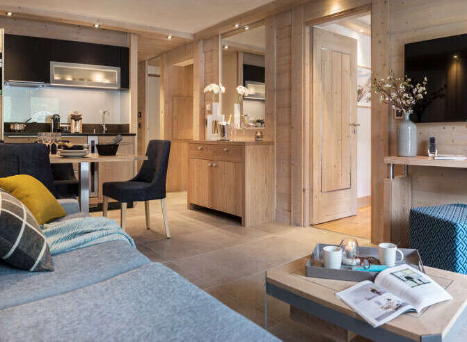 This stunning apartment boasts a spacious open-plan living area with a cozy sofa and modern kitchen.